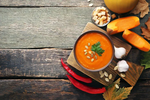 Tohum ve maydanoz ahşap masa üzerinde kase kabak çorbası