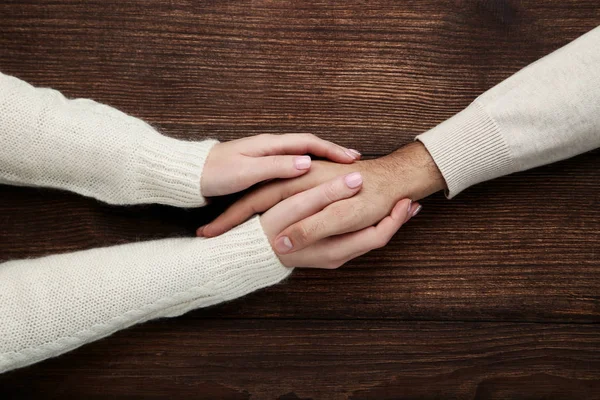 茶色の背景にお互いを持っている女性と男性の手 — ストック写真