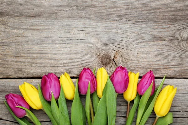 Gri ahşap masa üzerinde Lale buketi