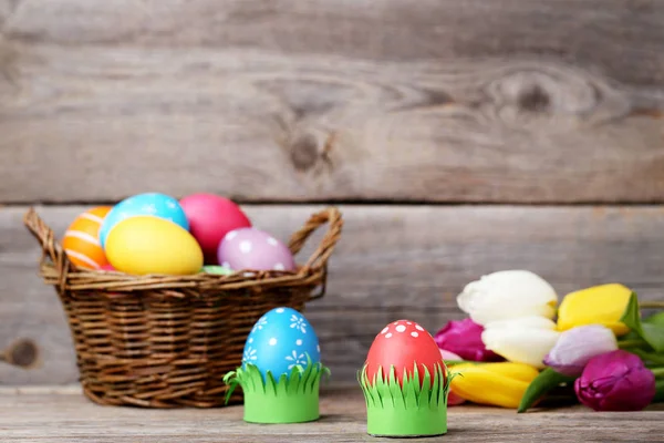 Lale Gri Ahşap Masa Üstünde Sepetle Renkli Paskalya Yumurtaları — Stok fotoğraf