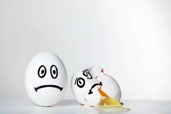 Яйца со смешными лицами на сером фоне
