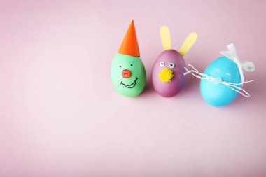 Pembe bir arka plan üzerinde Komik suratlar ile yumurta