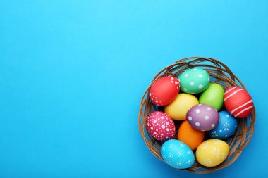 Sepette mavi arka plan üzerinde renkli Paskalya yumurtaları