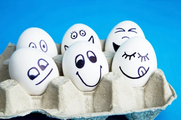 Ovos Com Rostos Engraçados Pacote Caixa Fundo Azul — Fotografia de Stock