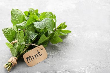 Gri ahşap masa üzerinde taze nane yaprakları