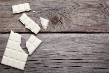 Gri ahşap masa üzerinde beyaz çikolata parçaları