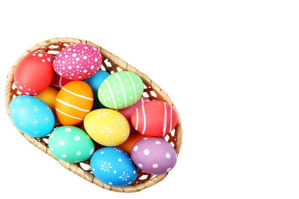 Colorful easter eggs in basket isolated on white background