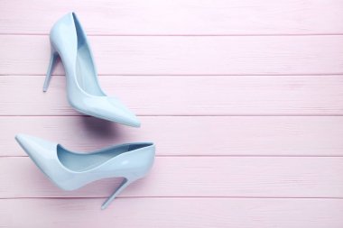 Pembe ahşap masada mavi topuklu ayakkabılar