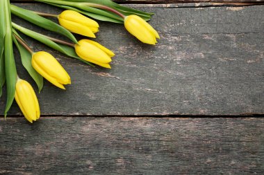 Gri ahşap masa üzerinde Sarı laleler buket