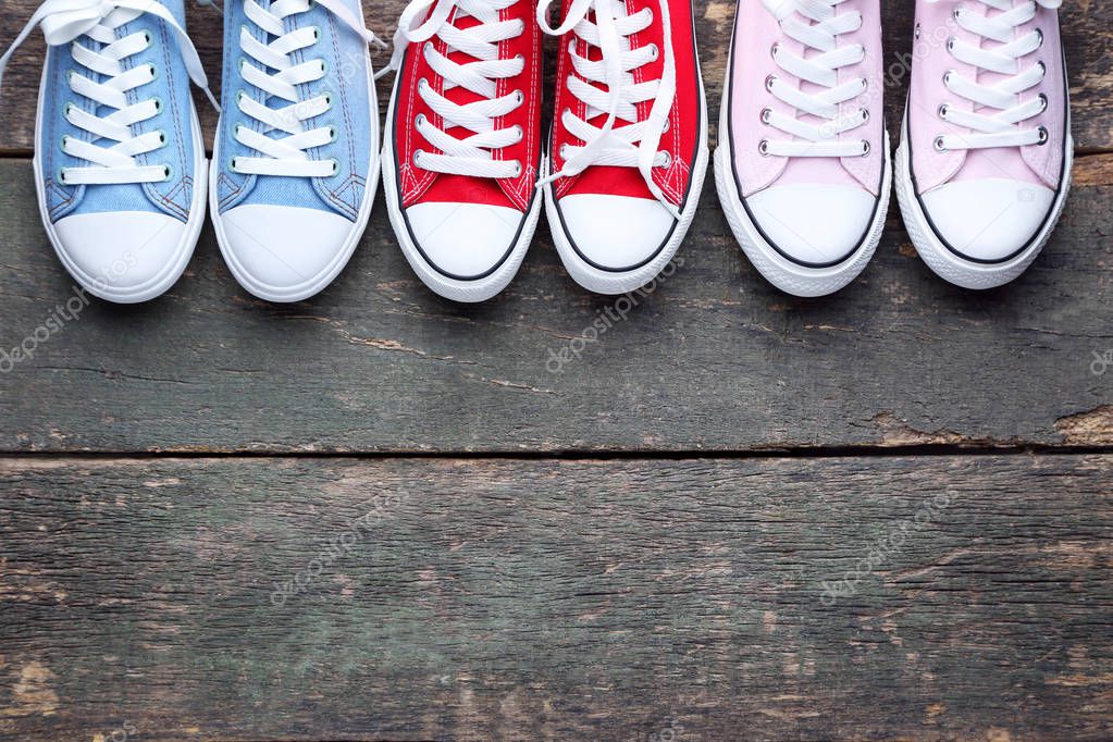 Different colorful sneakers on grey wooden table