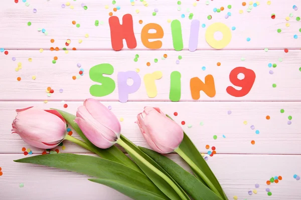 Lale çiçek pembe ahşap masa üzerinde yazıt Merhaba yaylı