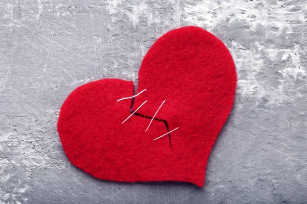 Coeur rouge cassé sur table en bois gris — Photo