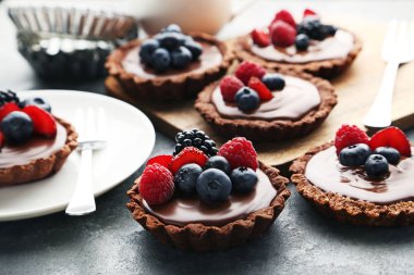 Gri ahşap masa üzerinde çilek ile çikolata tartlets