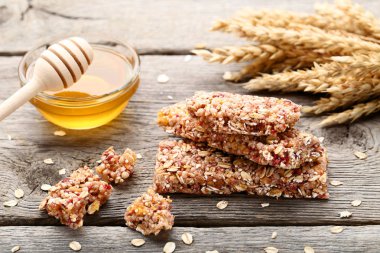 Ahşap masa kase ve buğday kulaklara bal ile lezzetli granola barlar