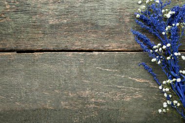 Mavi çiçekler ve gri ahşap masa üzerinde beyaz gypsophila