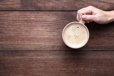 Kahve ahşap arka plan üzerinde tutan el