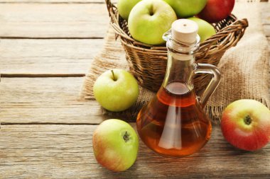 Elma sirkesi cam şişe sepet ve çuval bezi gri ahşap tablo