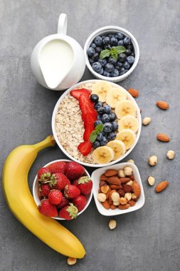 Çilek ve ahşap masa üzerinde süt kase yulaf gevreği