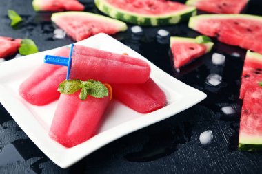 Plaka üzerinde siyah ahşap masa karpuz popsicles