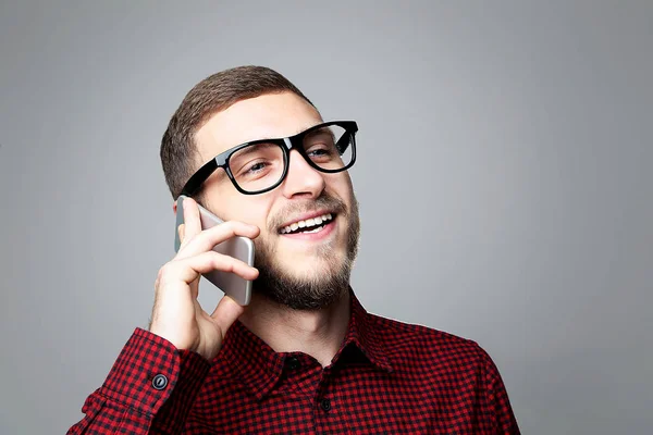 Junger Mann Mit Smartphone Und Brille Auf Grauem Hintergrund — Stockfoto