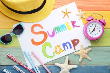 Çalar saat, güneş gözlüğü ve starfishes ahşap masa üzerinde yazıt yaz kampı