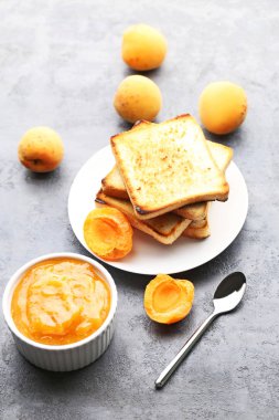 Ekmek tost gri ahşap masa üzerinde kase kayısı reçeli