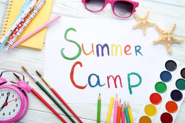 Çalar saat, güneş gözlüğü ve starfishes ahşap masa üzerinde yazıt yaz kampı