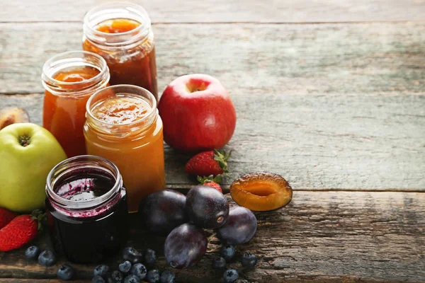 Glasgefäße Mit Verschiedenen Marmeladensorten Auf Holztisch — Stockfoto