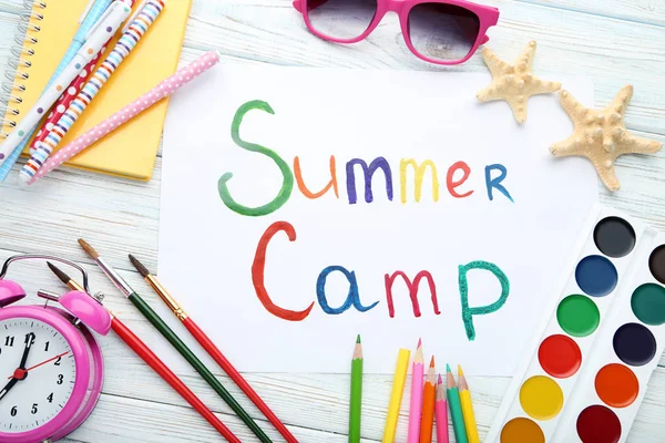 Çalar saat, güneş gözlüğü ve starfishes ahşap masa üzerinde yazıt yaz kampı