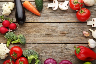 Çerçeve gri ahşap masa üzerinde çeşitli sebze