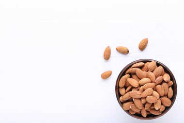 Beyaz ahşap masa üzerinde kase badem