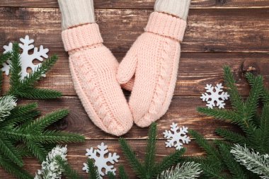 Kar taneleri ve köknar ağacı dallarıyla örülmüş eldivenler.