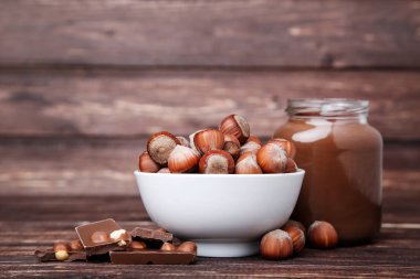 Kahverengi ahşap masada fındık ile erimiş çikolata