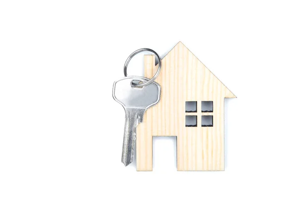 Серебряный ключ с деревянным домом на белом фоне — стоковое фото