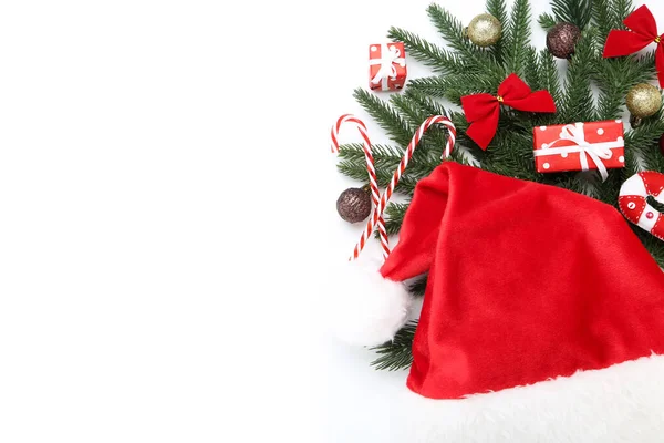 クリスマスツリーの枝におもちゃとサンタの帽子の上に白い背広 — ストック写真