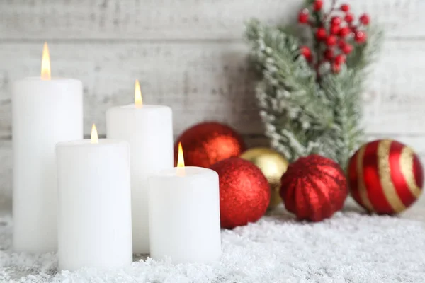 Рождественские свечи с игрушками для безделушек и елочными ветвями на белке — стоковое фото