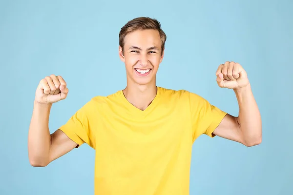 Portret van de jonge man in geel t-shirt op blauwe achtergrond — Stockfoto