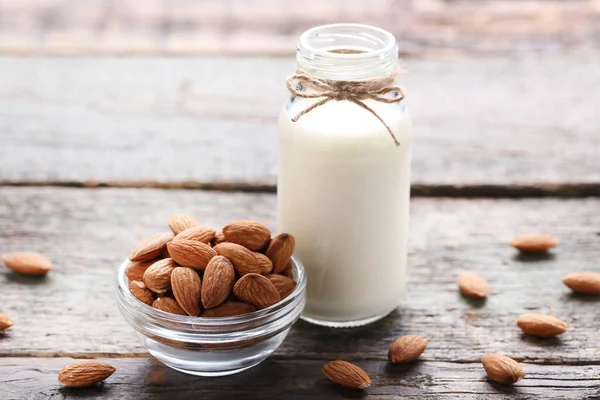 Susu almond dalam botol di meja kayu abu-abu — Stok Foto