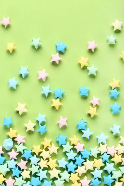 Coloridas estrellas de papel sobre fondo verde —  Fotos de Stock