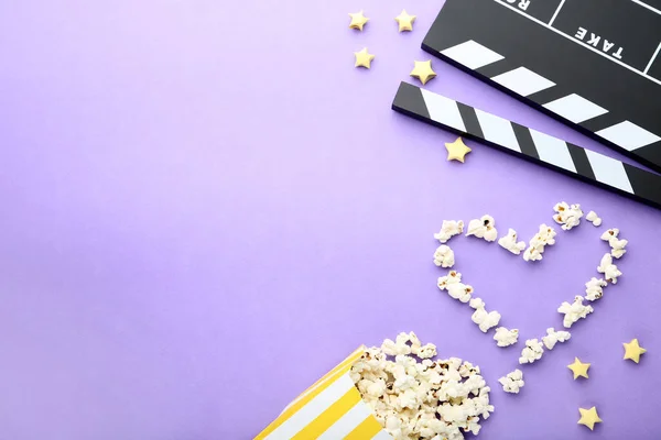 FILMKLAPPA med popcorn på lila bakgrund — Stockfoto