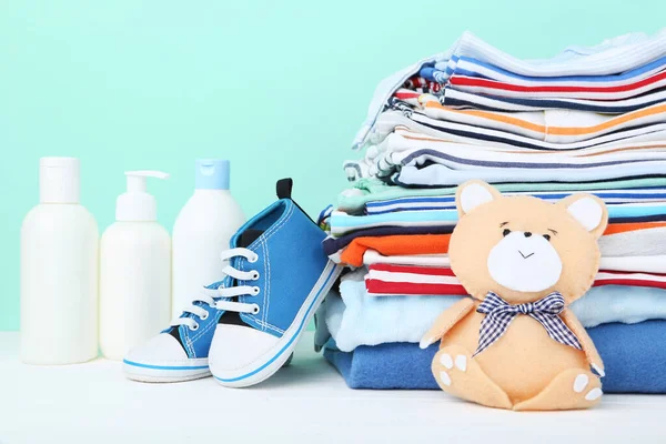 Folded clothes with soft bear toy and baby supplies