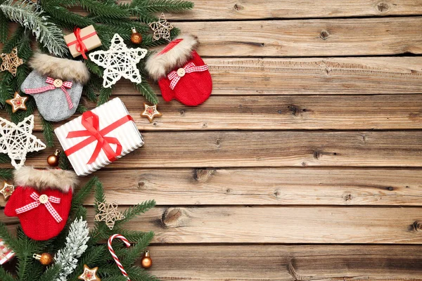 圣诞树分枝上有礼品盒和棕色木材手套 — 图库照片