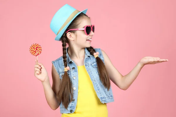 Vacker ung flicka med söt Lollipop på rosa bakgrund — Stockfoto