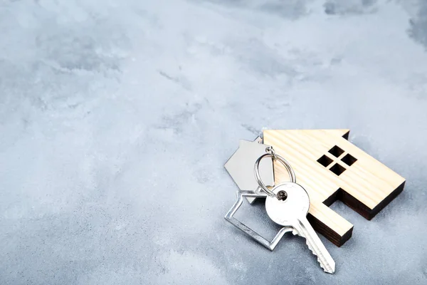 Silver key with house symbol on grey background — Stock Photo, Image