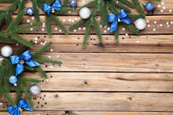 Christmas tree branches with toys on brown wooden table — Stock Photo, Image