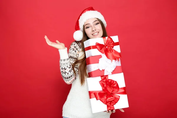 Gyönyörű nő pulóvert visel, télapó kalap és a kezében ajándék doboz — Stock Fotó