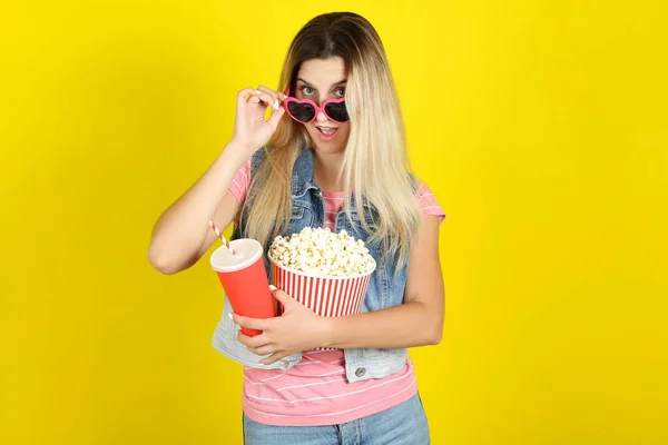 Junge Frau mit Sonnenbrille hält Eimer mit Popcorn und Papier in der Hand — Stockfoto