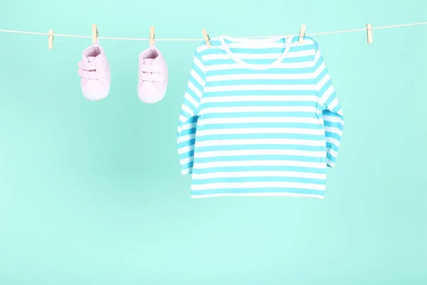 Bayi pakaian tergantung di latar belakang biru — Stok Foto