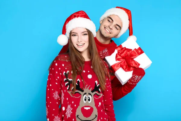 Hermoso woamn y el hombre que usa suéteres de Navidad y la celebración de g — Foto de Stock