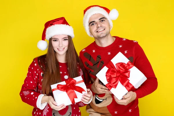 Homem e mulher bonita em camisolas de Natal e chapéu de santa hol — Fotografia de Stock